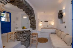 a bedroom with a bed and a stone wall at Adamma Tinos in Kékhros