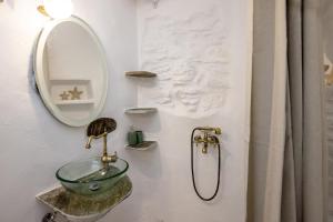 a bathroom with a sink and a mirror at Adamma Tinos in Kékhros