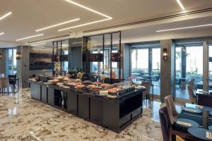 a buffet line in a hotel lobby with tables and chairs at Hotel & Resort Tre Fontane Luxury in Portici