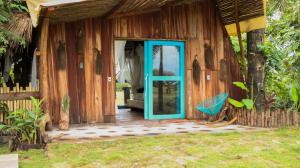 a house with a blue door and a chair outside at wellgaya ecovillas in Villa Flor