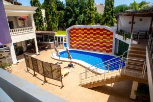 a swimming pool with a slide in a house at Hotel Les Orchidées in Cotonou
