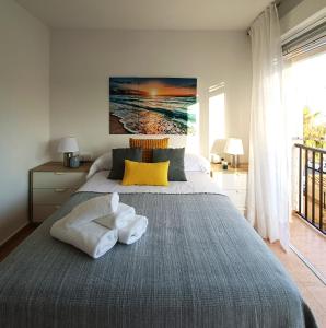 a bedroom with a bed with towels on it at Tropicana Suite con salida directa al mar y piscina in Roquetas de Mar