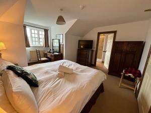 a bedroom with a large bed with a towel on it at True Lovers Knot in Blandford Forum