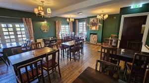 a restaurant with wooden tables and chairs and green walls at True Lovers Knot in Blandford Forum