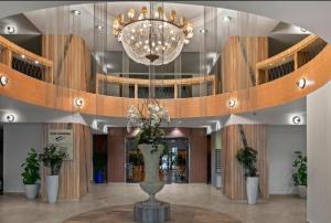 a lobby with a large chandelier and a vase with flowers at CENTRAL CHIC APARTAMENT with SPA and GYM in Bucharest