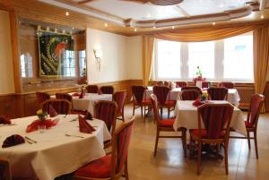 a dining room with white tables and red chairs at Zur alten Quelle in Drolshagen