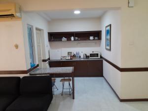 Una cocina con un sofá y una mesa en una habitación. en Jalan Kamus, Simpang Empat Holiday home, en Kampong Pulau Sebang