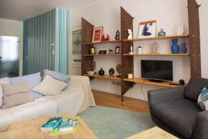 a living room with a couch and a television at Workshop in Béziers