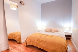 a bedroom with a bed and two tables and a mirror at Workshop in Béziers