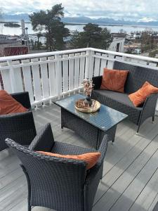 a patio with chairs and a table on a deck at Sentralt, kort vei til byens fasiliteter in Molde