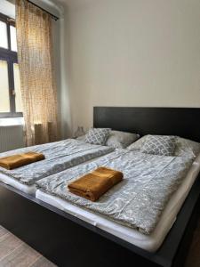 duże łóżko z dwoma brązowymi poduszkami w obiekcie Kovarik Apartments I w Ołomuńcu
