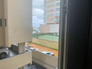 a view of a parking lot from a window at Apartamento Centro - Jardim Caiahu - in Mongaguá