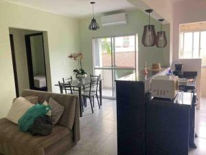 a living room with a couch and a table at Apartamento Centro - Jardim Caiahu - in Mongaguá