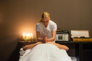 a woman is sitting on a bed with her leg in a massage at Grand Hotel Ter Duin in Burgh Haamstede
