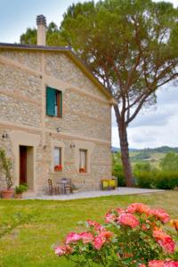 a stone house with pink flowers in front of it at Casa Patrizia in Querceto