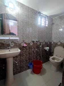 a bathroom with a sink and a toilet and a mirror at Saudia residential hotel in Sylhet