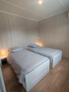 two beds in a room with wooden walls at Ben Chalet in Carlux