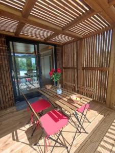 a patio with a table and chairs on a deck at Maison 3 pièces, climatisé, calme, "Le chalet" in Carlux