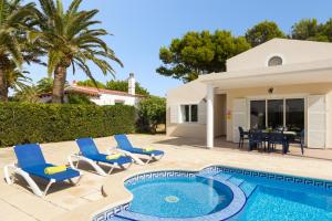 a villa with a swimming pool and blue chairs at Villa Roser in Ciutadella