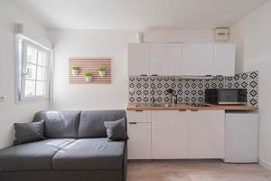 a living room with a couch and a kitchen at Appartement Disney-Paris Ferrieres-en-brie in Ferrières-en-Brie