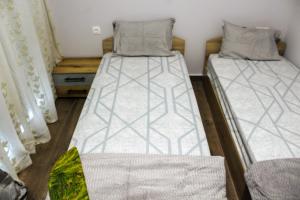 two twin beds in a room with curtains at Konstantinos Apartment in Nea Moudania