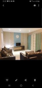 格兰贝伊Coastal Bliss Apartment Mauritius的客厅配有沙发和墙上的时钟