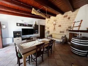 a dining room with a table and a wine barrel at Villa Assuntina in Cellino San Marco