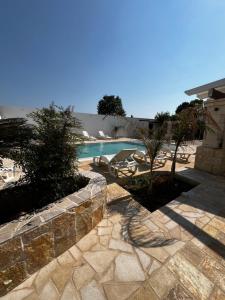 a backyard with a swimming pool and a stone wall at Villa Assuntina in Cellino San Marco