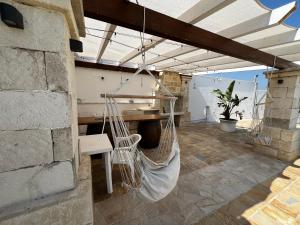 a porch with a hammock hanging from a building at Villa Assuntina in Cellino San Marco