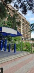 una parada de autobús azul frente a un edificio en GeoFamilyNest, en Tiflis