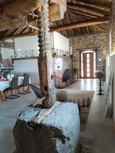 a room with chairs and a tree in the middle at Villa Alessio - Etna Historic Winery Villa - Ancient Palmento with pool in Puntalazzo