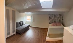 a small bedroom with a bed and a couch at Casa do Areal in Laxe