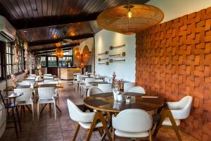 a restaurant with tables and chairs and a brick wall at Dolphin Hotel in Fernando de Noronha