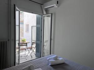 a bedroom with a bed and a balcony with a table at Miranda's Apartment Koukaki in Athens