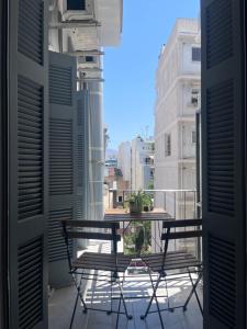 a balcony with a table and chairs on a balcony at Miranda's Apartment Koukaki in Athens