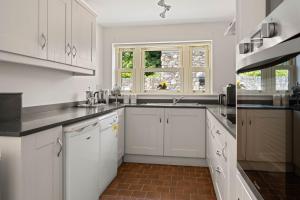 a kitchen with white cabinets and a sink at Joe's Corner House in Shanagarry