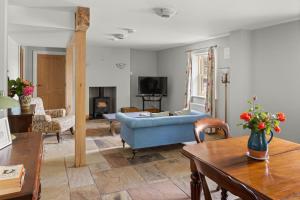 a living room with a blue couch and a tv at Joe's Corner House in Shanagarry