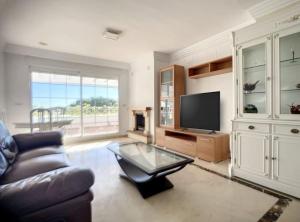 a living room with a couch and a television at a beautiful and tranquil apartment in the heart of marbella in Marbella