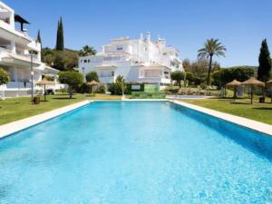 a large swimming pool in front of a building at a beautiful and tranquil apartment in the heart of marbella in Marbella