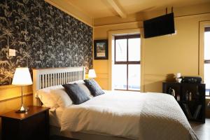 a bedroom with a bed and a black and white wallpaper at The Dundrum Inn B&B in Dundrum