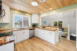 a kitchen with white cabinets and a wooden ceiling at High Seas in DeBordieu Colony home by Peace Vacations in Georgetown +33 photos
