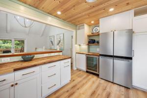 a kitchen with white cabinets and a wooden ceiling at High Seas in DeBordieu Colony home by Peace Vacations in Georgetown