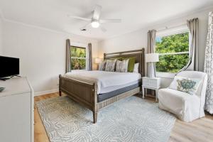 a bedroom with a bed and a chair at High Seas in DeBordieu Colony home by Peace Vacations in Georgetown