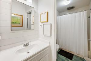 a white bathroom with a sink and a toilet at High Seas in DeBordieu Colony home by Peace Vacations in Georgetown