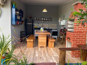 a kitchen with a table and benches in a room at Casinha Azul in Prado