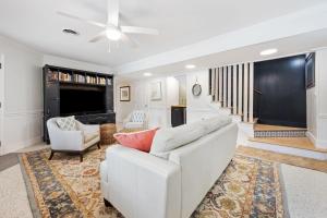 a living room with a white couch and a tv at High Seas in DeBordieu Colony home by Peace Vacations in Georgetown