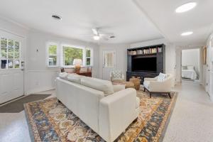 a living room with a white couch and a tv at High Seas in DeBordieu Colony home by Peace Vacations in Georgetown
