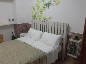een slaapkamer met een bed met een houten hoofdeinde bij Giardini Di Capodimonte Apartment in Napels