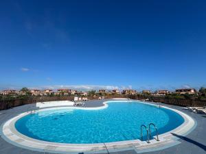 a large swimming pool with blue water at Giraud I - Luxurious secluded villa next to the sea in Lajares