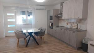 a kitchen with a table and chairs in a room at Apartment Modrić Zadar II in Zadar +13 photos